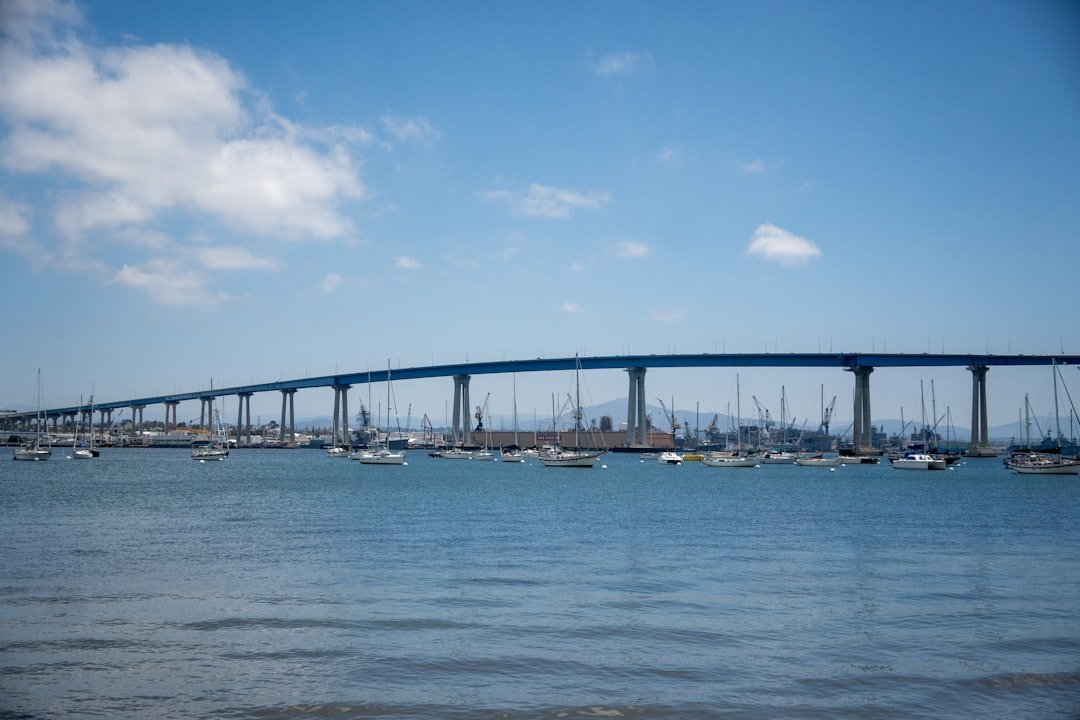 A bridge spans across a calm, blue bay.