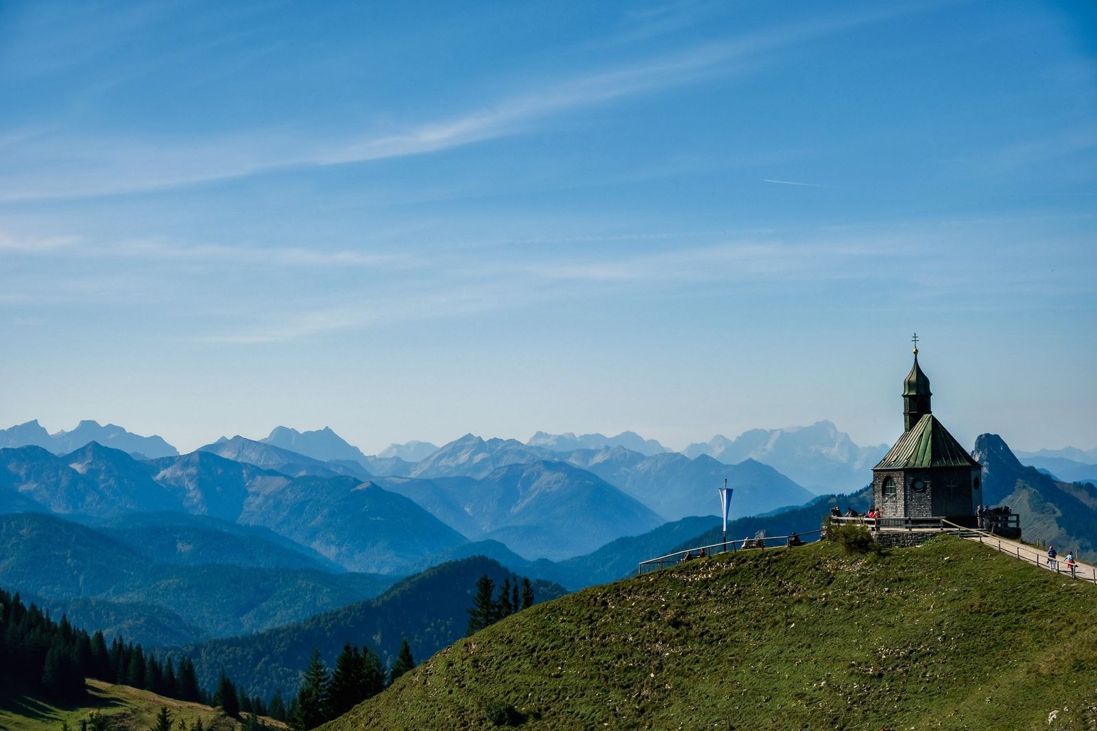 Serene view of a chapel atop a hill in the picturesque Bavarian Alps, Germany.